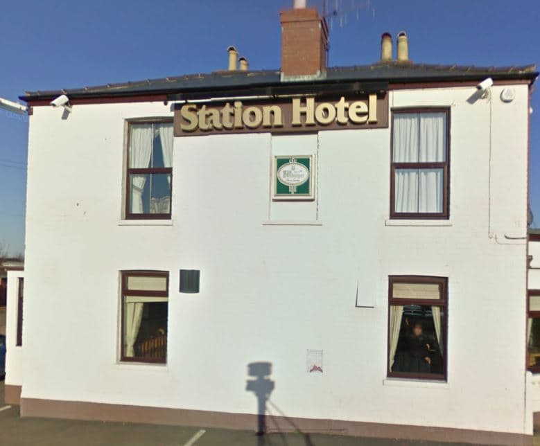 White building with "Station Hotel" sign, large windows, and a clear blue sky in Patrington, Yorkshire.