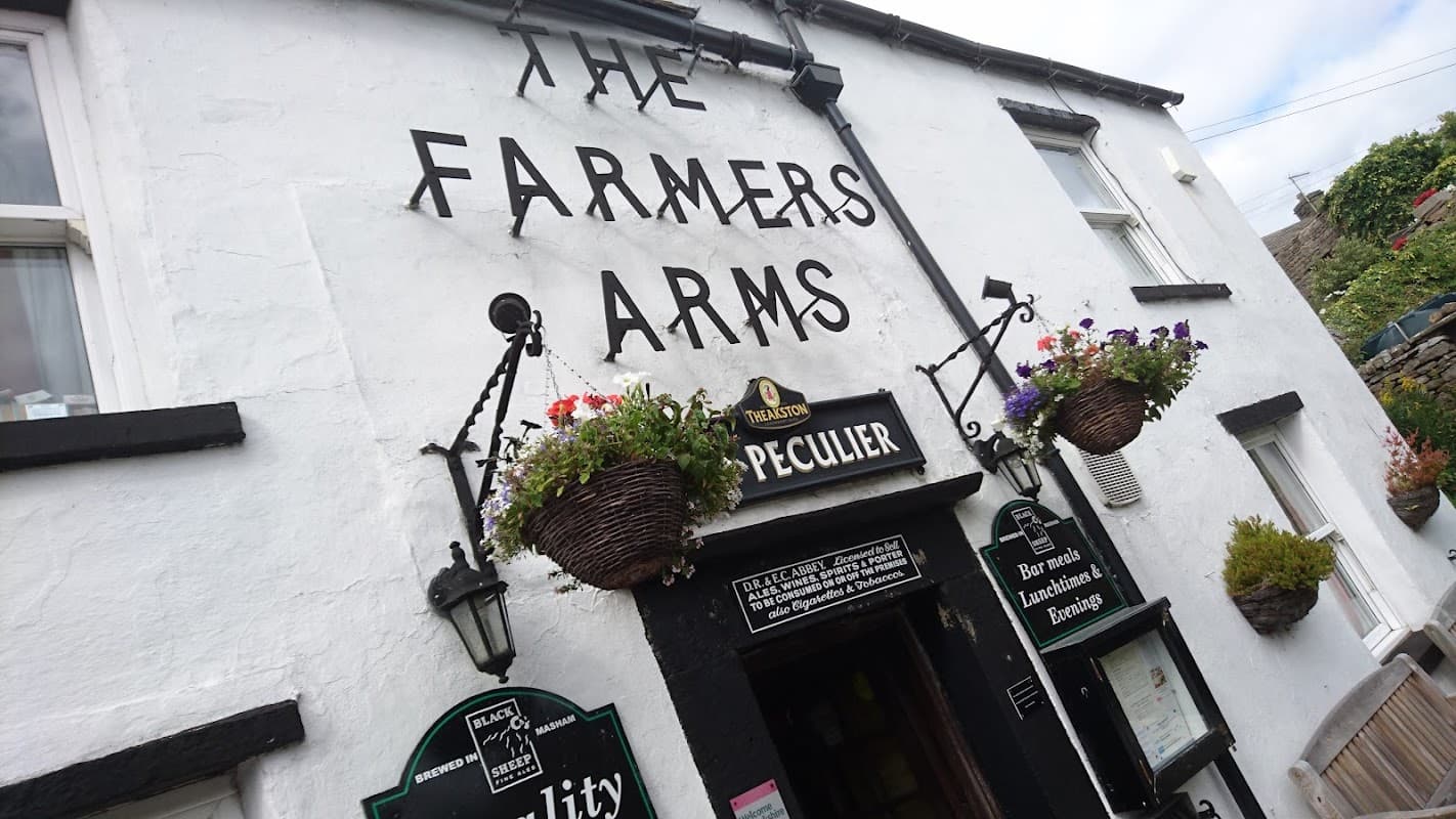 The Farmers Arms pub features a white exterior, hanging flower baskets, and a sign displaying "Peculier."