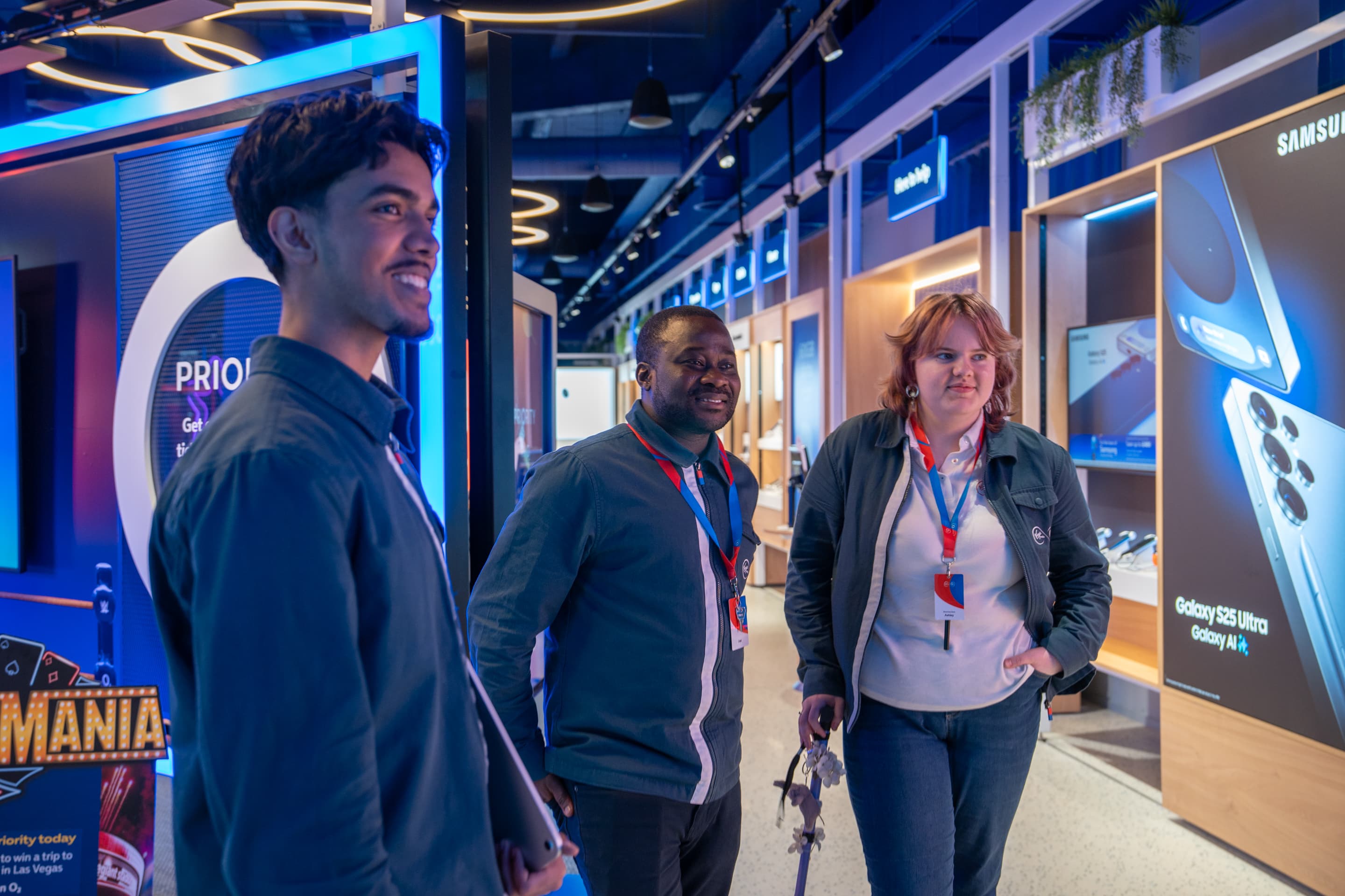 Three people smiling inside a modern technology store