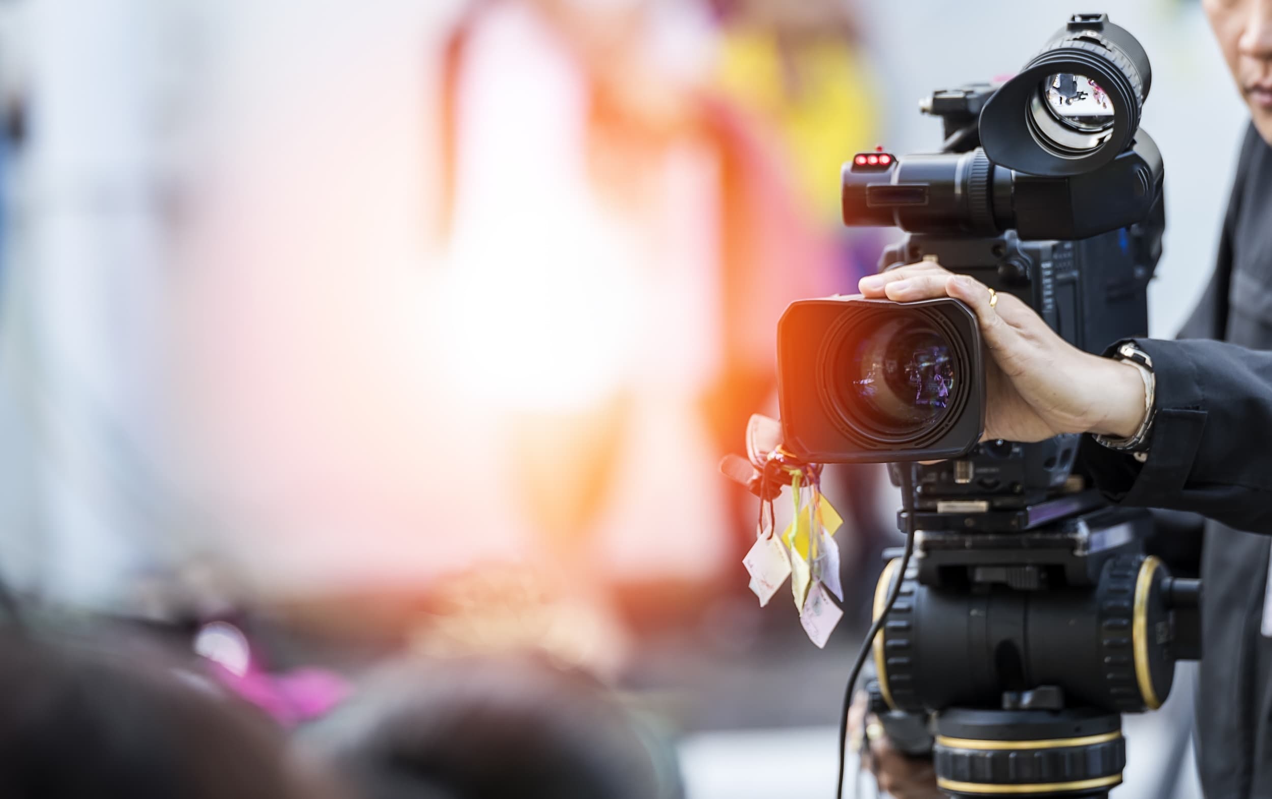 Close-up of a person operating a professional video camera