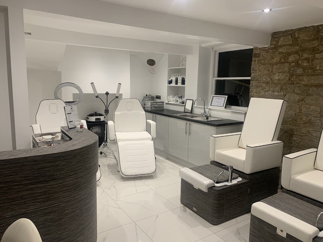 Modern beauty salon interior with sleek white chairs, a reception desk, and stylish decor in a serene setting.