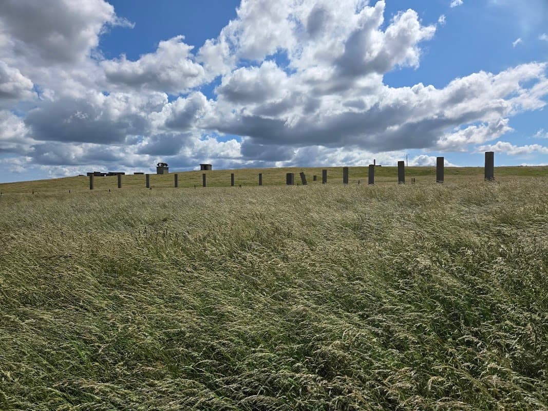 Stone pillars on grassy hill under a cloudy sky at Former RAF Bempton, Yorkshire.