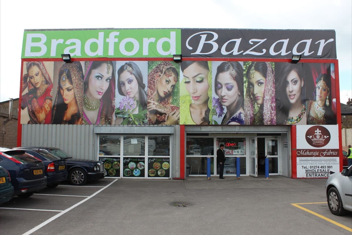 Colorful storefront featuring diverse models in traditional attire, showcasing the name "Bradford Bazaar" prominently above.
