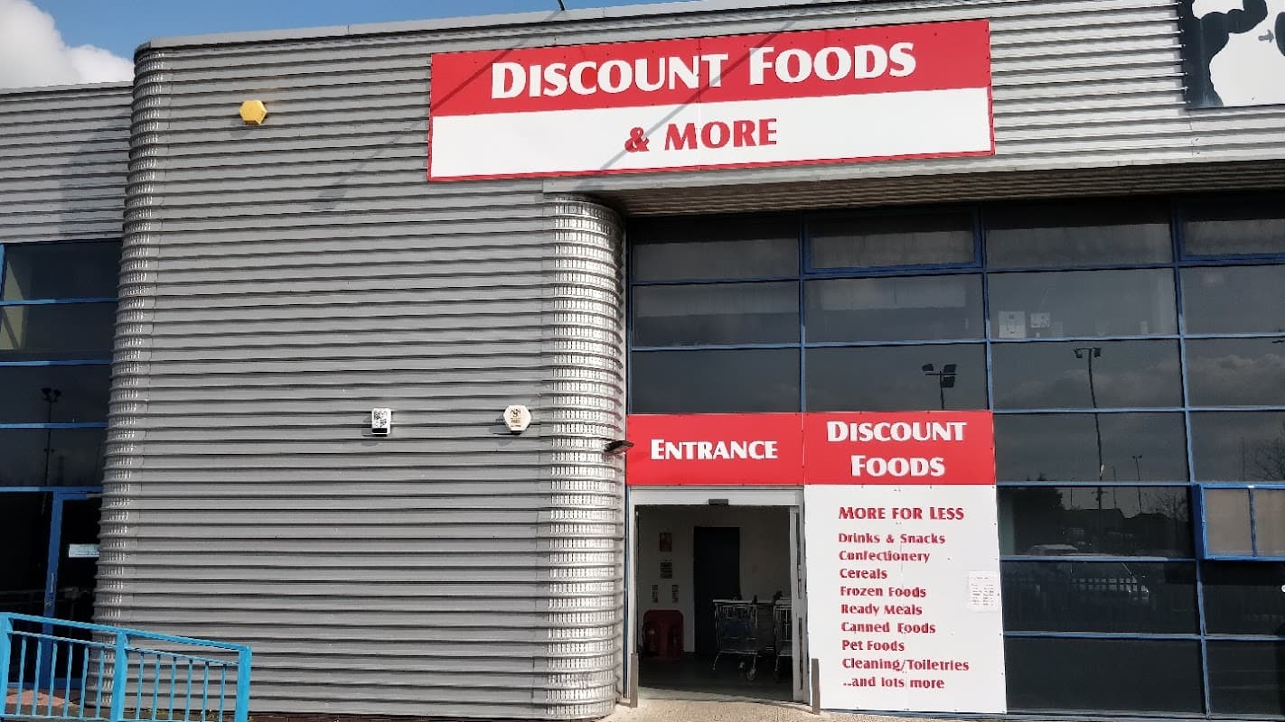 Discount Foods & More storefront with large red signage, entrance door, and list of products offered.