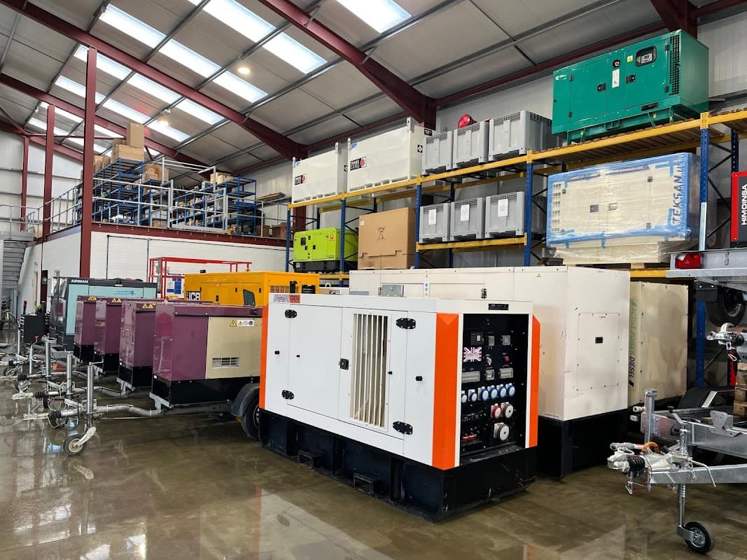 Industrial warehouse with various generators and equipment, stacked shelves, and a clean concrete floor.