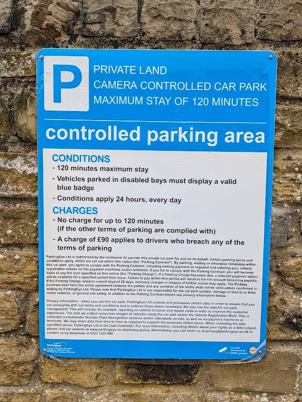 Blue sign detailing parking regulations, maximum stay of 120 minutes, and charges for violations in Lidl Car Park.
