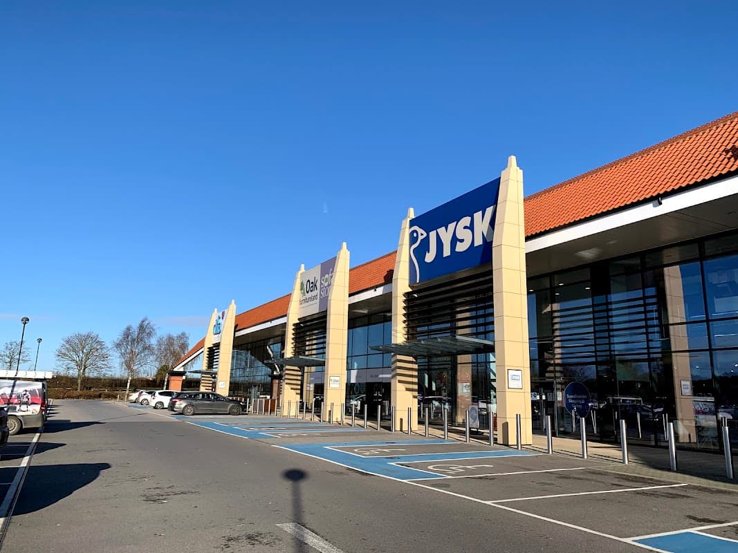 JYSK store front at Clifton Moor Retail Park, with clear blue sky and parking spaces in view.