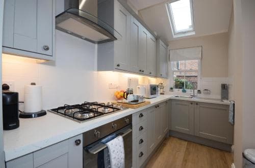 Cozy Yorkshire kitchen with grey cabinets, skylight, fruit bowl, and modern appliances, creating a warm, inviting atmosphere.