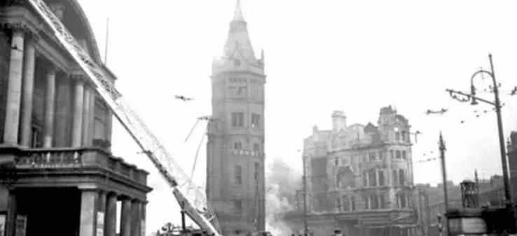 Historic clock tower amidst Victorian buildings and street