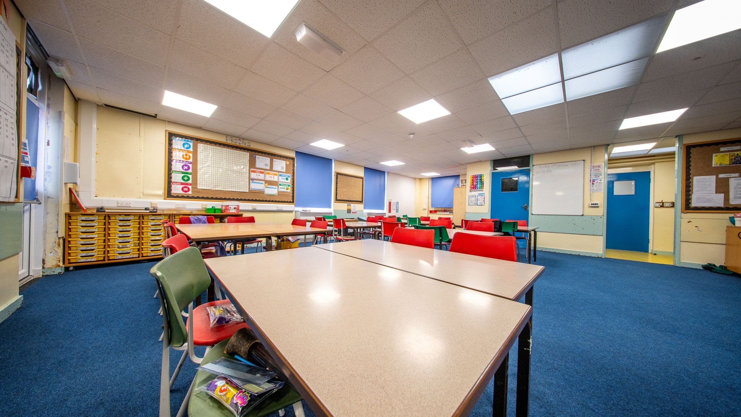 Empty classroom with colorful chairs and educational posters