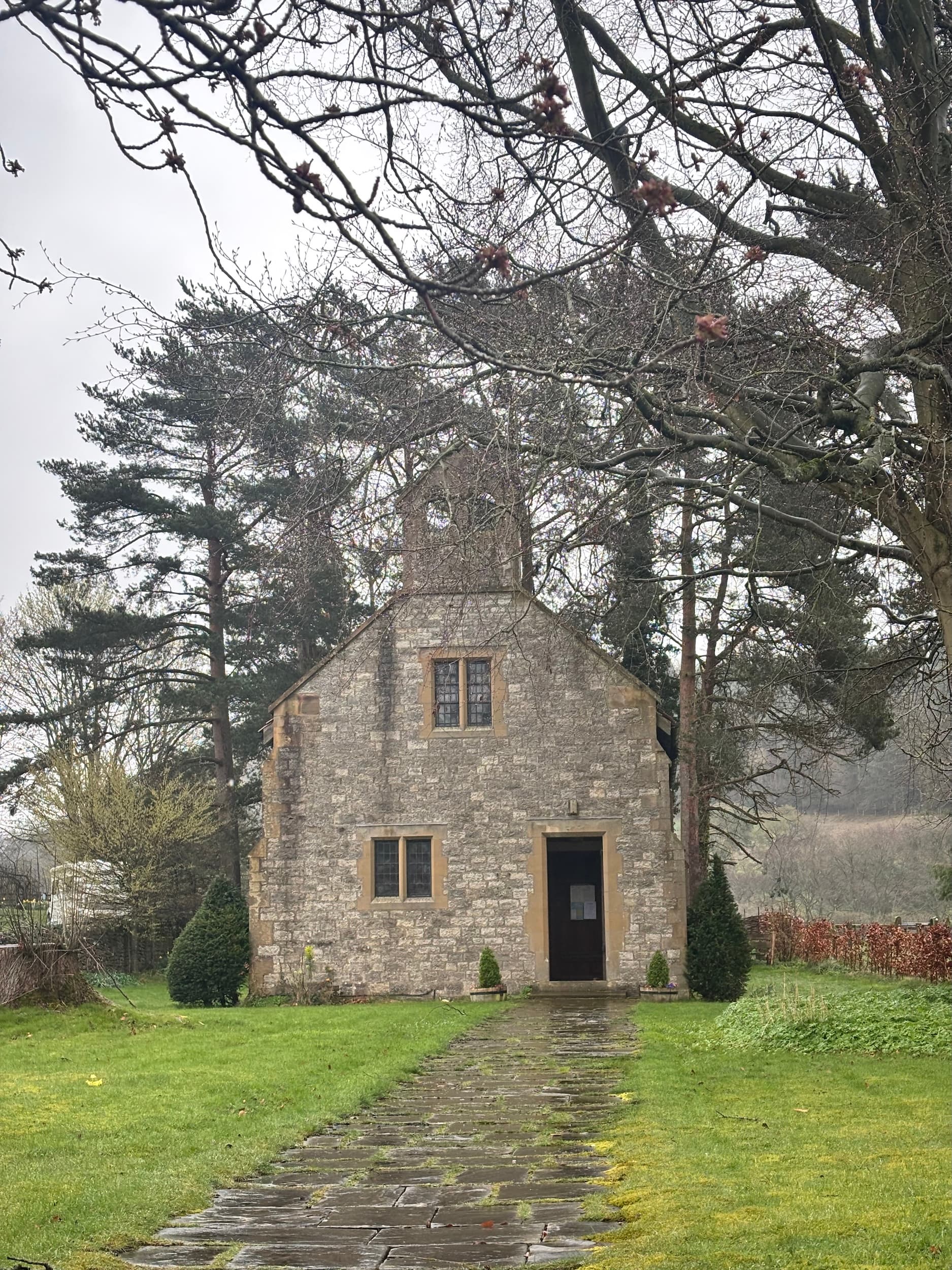 Charming stone church, St Chad's at Hutton le Hole, with windows surrounded by trees