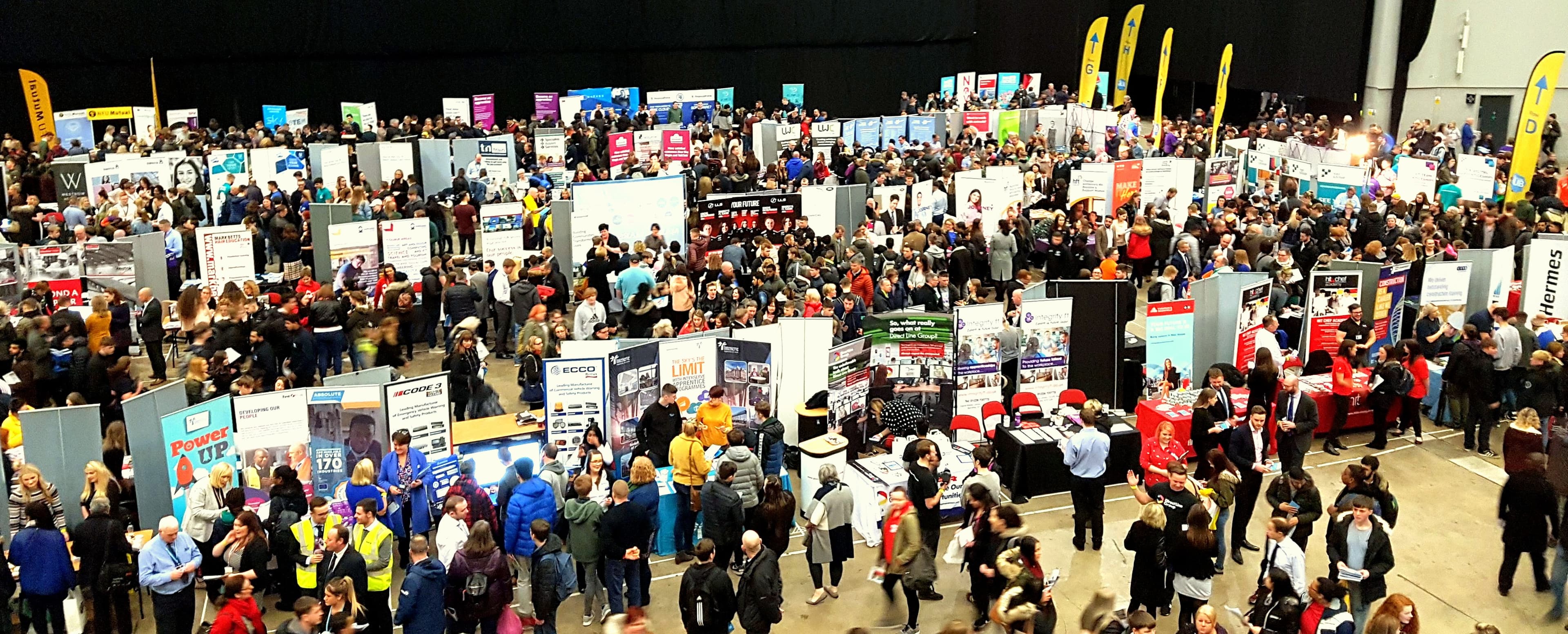 Crowded exhibition hall with numerous booths and visitors