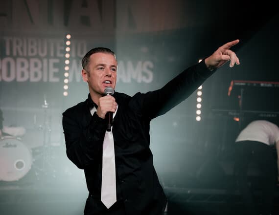 Performer on stage with microphone pointing towards audience