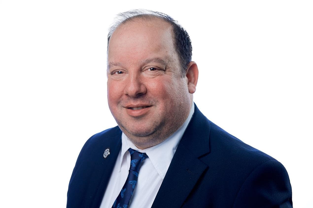 Smiling person in a suit and tie on a white background