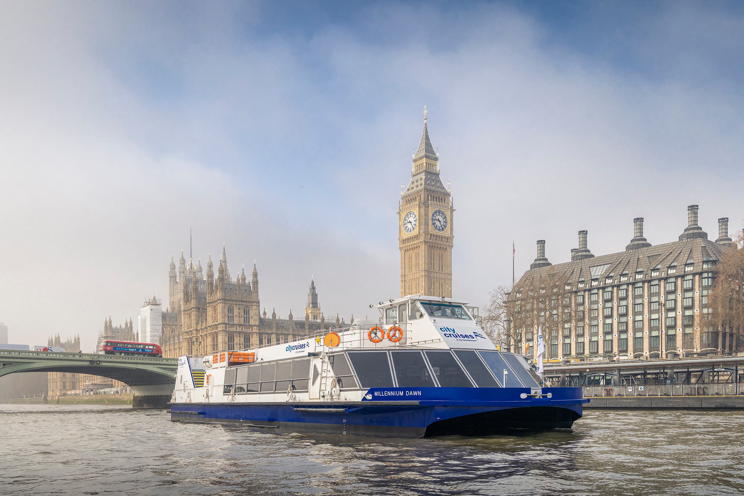 Riverboat cruising past Big Ben and Houses of Parliament