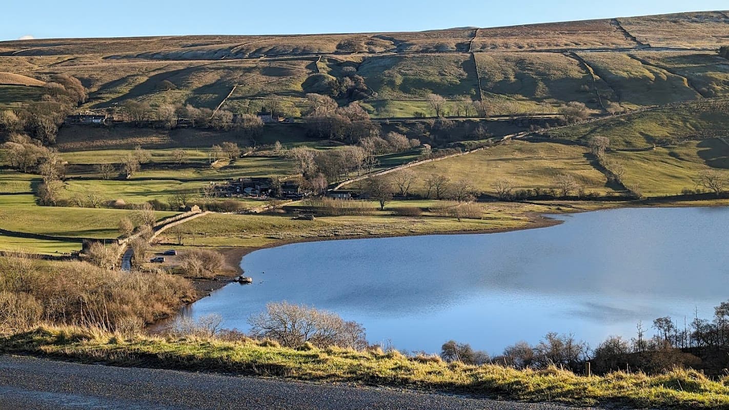 Serene lake reflecting the landscape, surrounded by rolling hills and lush greenery in Semer Water Nature Reserve.