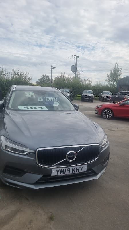 Gray Volvo SUV in foreground with price tag, surrounded by various cars at Station Garage in Flaxton, Yorkshire.