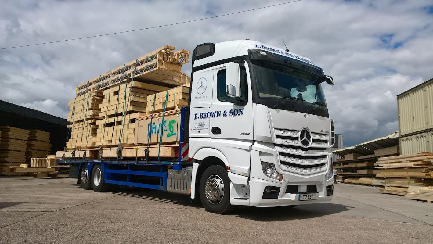 E. Brown & Son truck loaded with wooden pallets, parked in a yard under a cloudy sky in South Cave, Yorkshire.