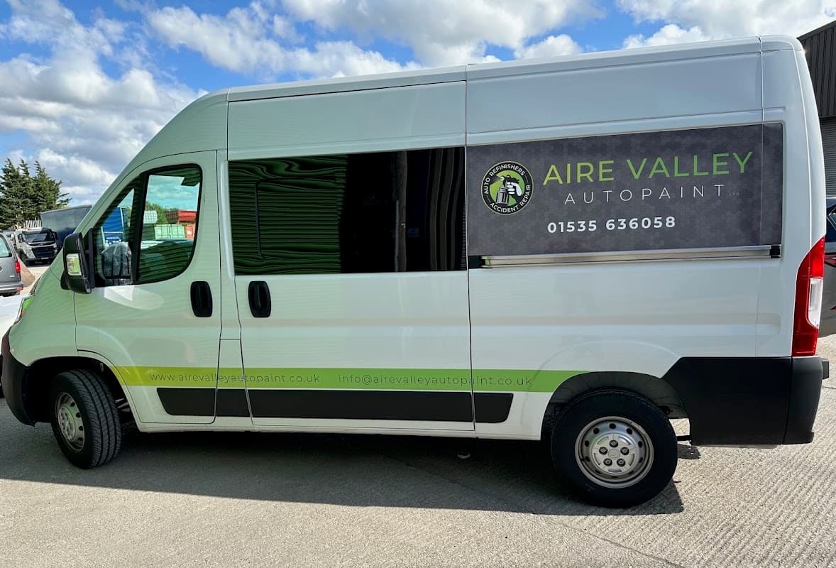 Aire Valley Autopaint Ltd van parked outside, featuring a logo, contact info, and a clear blue sky in the background.