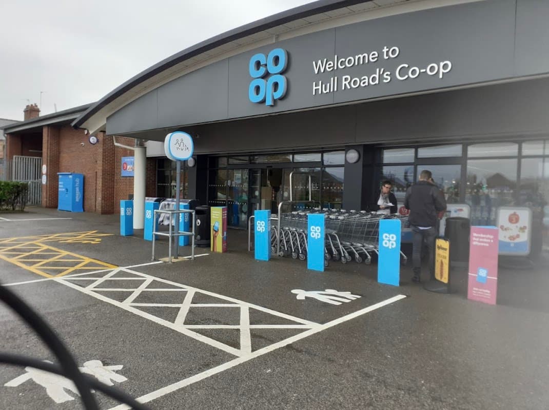 Co-op Food storefront with shopping carts outside, signage welcoming visitors, and accessible parking spaces.