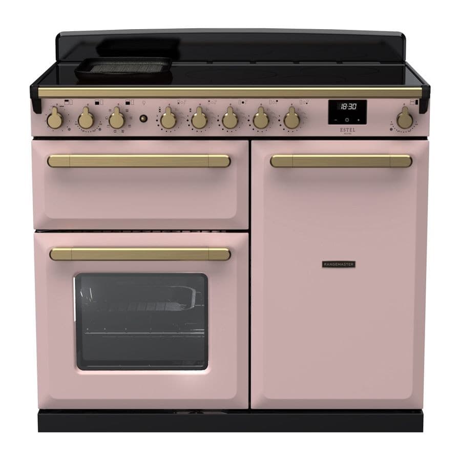 Pale pink induction range cooker with antique brass knobs, featuring a black glass top, two ovens, and a digital display, combining elegance and functionality.