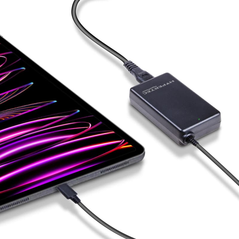 Black Hypertec HyperPower 65W charger connected to a device, featuring a sleek design, compact size, and a green LED indicator light.