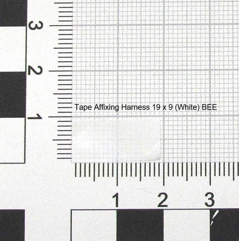 White tape affixing harness measuring 19 x 9, featuring a grid pattern, with a ruler for scale in the background.