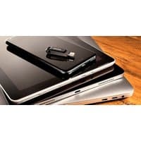 Black SanDisk Ultra Dual Drive Go with USB Type-A and USB Type-C connectors on a stack of electronic devices.
