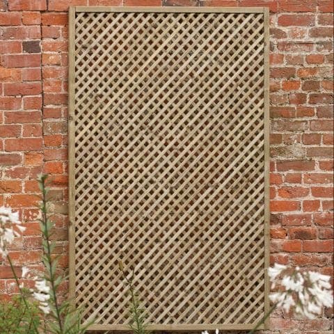 5'11" x 2'11" wooden lattice panel in a diamond pattern, featuring a natural wood finish, set against a rustic brick wall with white flowers in the foreground.
