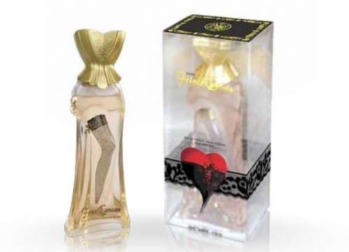 Clear glass bottle shaped like a woman's silhouette, adorned with a golden corset top and a decorative black lace band, alongside a stylish box featuring a heart design.