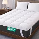 White quilted mattress topper with elasticated straps on a double bed, thick and plush for luxury comfort.