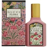 Pink Gucci Flora Gorgeous Gardenia perfume bottle with yellow cap, floral design, and matching decorative box.