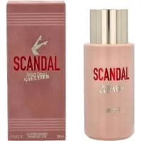 Pink Jean Paul Gaultier Scandal body lotion bottle with gold cap and matching box featuring logo and leg graphic.