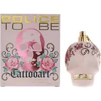 Skull-shaped pink perfume bottle with floral tattoo design, gold cap, and matching box labeled "Police To Be Tattooart."
