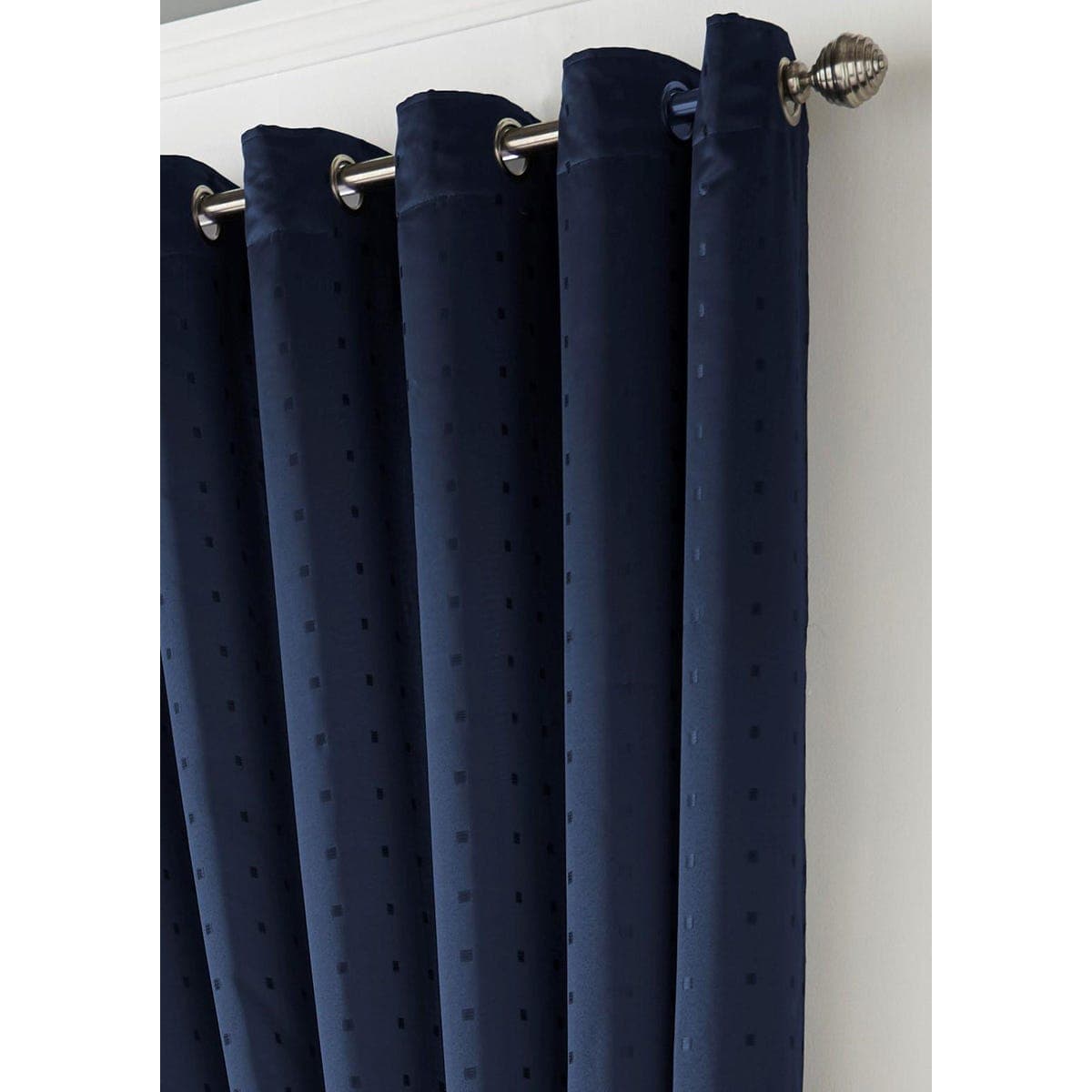 Deep blue lined curtains with a textured dot pattern, featuring silver grommets for easy hanging, elegantly draping from a metallic rod.
