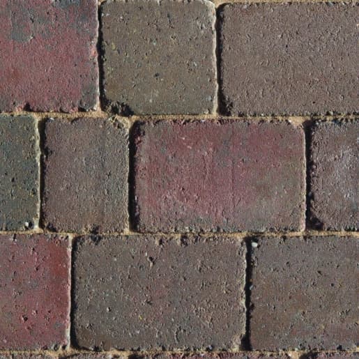 Rustic rumbled concrete block paving in shades of brown and red, featuring a textured surface, with dimensions of 100mm x 134mm x 50mm, ideal for outdoor use.