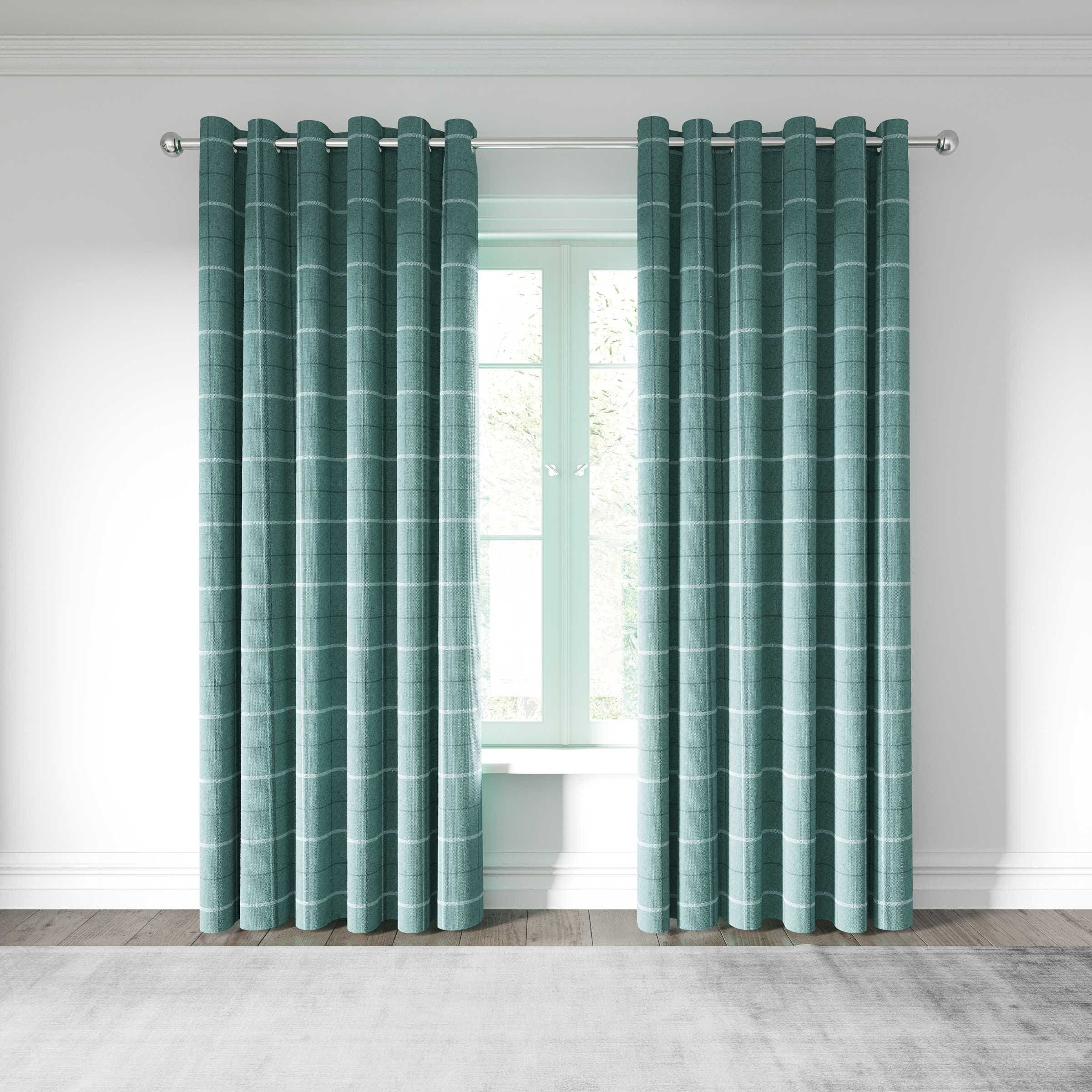 Woven lined curtains in a soft teal color with a subtle striped pattern, featuring silver curtain rings, hanging elegantly by a light-filled window.