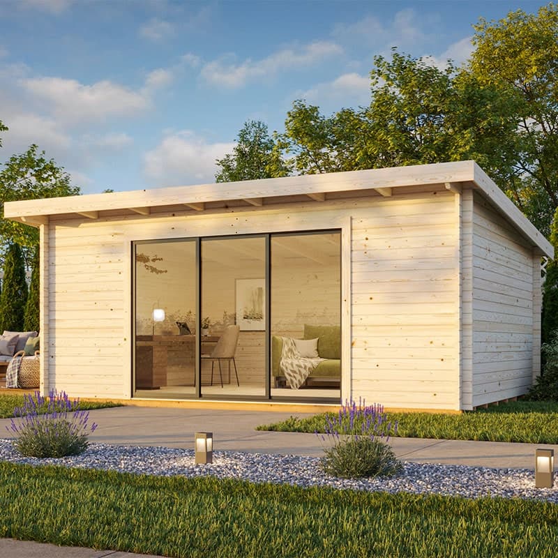 Light-colored wooden log cabin office featuring large sliding glass doors, a flat roof, and a modern design, set in a landscaped garden with greenery and pathway lighting.