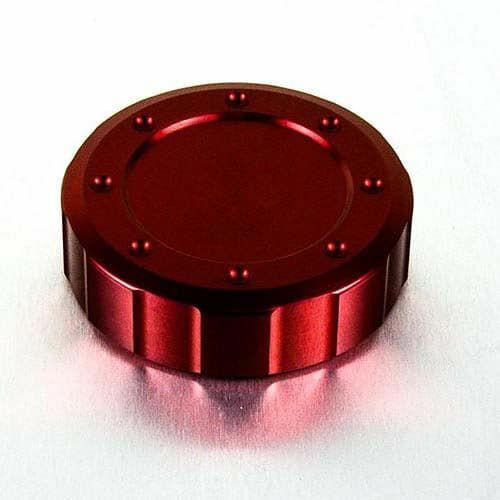 Red anodized aluminum reservoir cap, 61mm in diameter, featuring a smooth central surface and a ridged edge with decorative bolts around the perimeter.