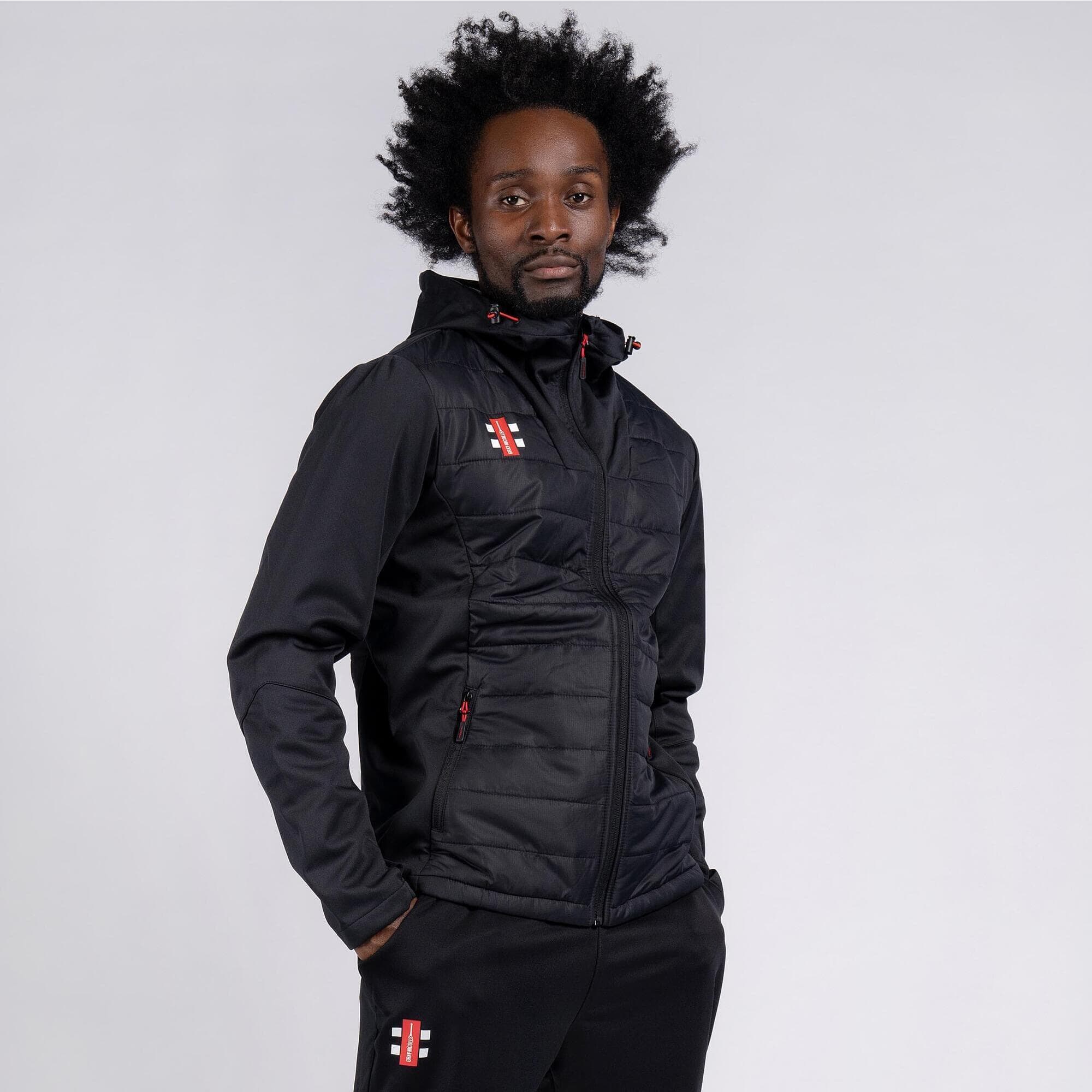 Black full zip jacket with a quilted front, featuring red and white logo accents, zippered pockets, and a hood, made from lightweight, performance fabric.