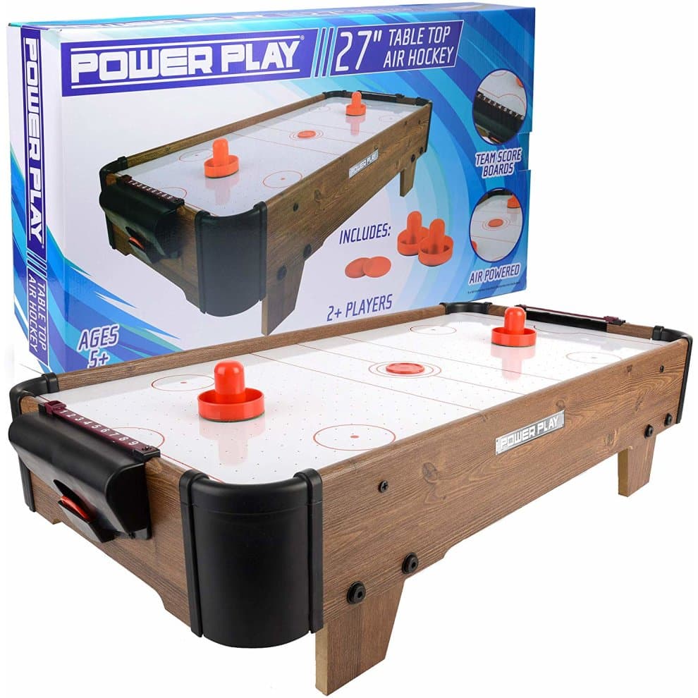 Dark brown air hockey table with a smooth white playing surface, red pucks, and scoreboards, featuring a sturdy wooden frame and compact design for tabletop play.