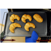 Adjustable non-stick baking shelf with mesh surface, holding four croissants and a roll, blue oven mitt visible.