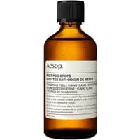 Amber glass bottle of Aesop Post-Poo Drops with black cap and white label featuring product details.