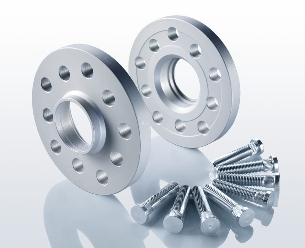 Two silver aluminum track widening spacers, each 20mm thick, with four holes, accompanied by a set of six silver bolts for installation.