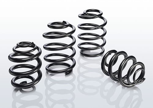Black coil springs from the EIBACH E10-15-022-02-22 Suspension Kit, showcasing a sleek, metallic finish with varying diameters and tightly wound coils for enhanced vehicle performance.