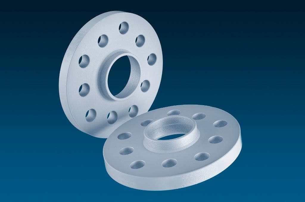 Silver aluminum wheel spacers with a smooth finish, featuring 4 holes each, designed for track widening of 15mm per spacer, totaling 30mm per axle.