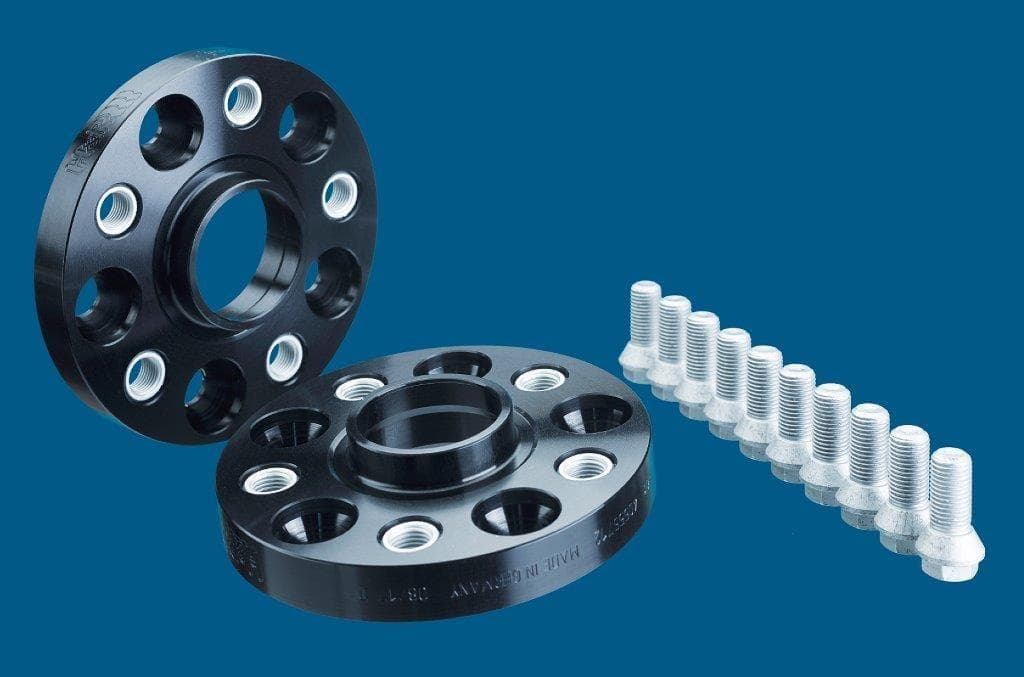 Black aluminum wheel spacers with five holes, 25mm thickness each, accompanied by silver wheel bolts, designed for track widening by H&R.