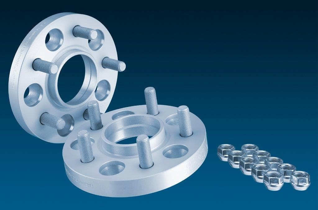 Silver aluminum H&R 5065640 TRAK+® wheel spacers, 25mm thick, featuring five holes and accompanying bolts, designed for track widening of 50mm per axle.