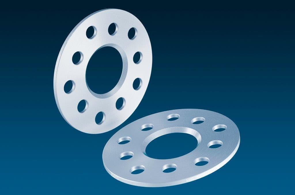 Silver aluminum wheel spacers with a 5mm thickness, featuring four holes and a central opening, designed for track widening with a total axle increase of 10mm.
