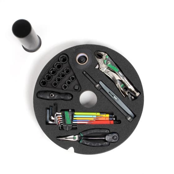 Kielder Layer Cake Hand Tool Kit features a black circular foam insert with various tools, including pliers, wrenches, a pen, and colorful screwdrivers, all organized neatly.